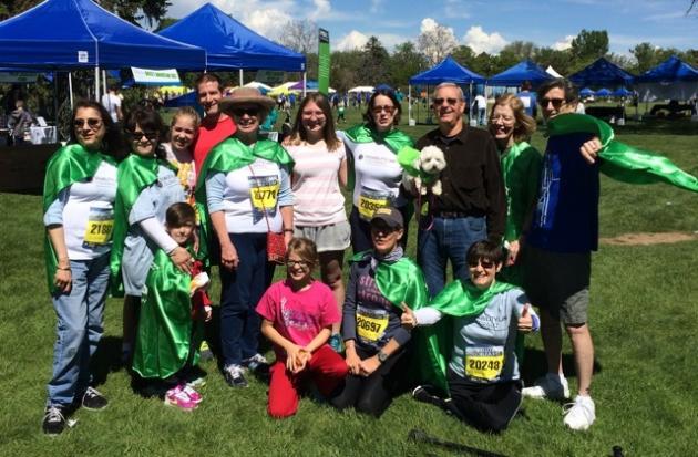 photo of DLC group who walked the 5k wearing their green capes and smiling for the camera at Colfax in 2015