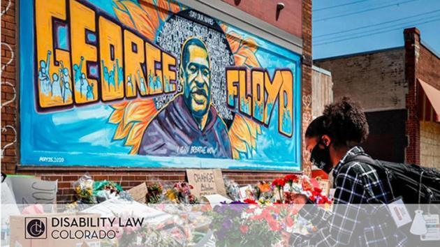 picture of young Black man placing a red carnation at memorial for George Floyd